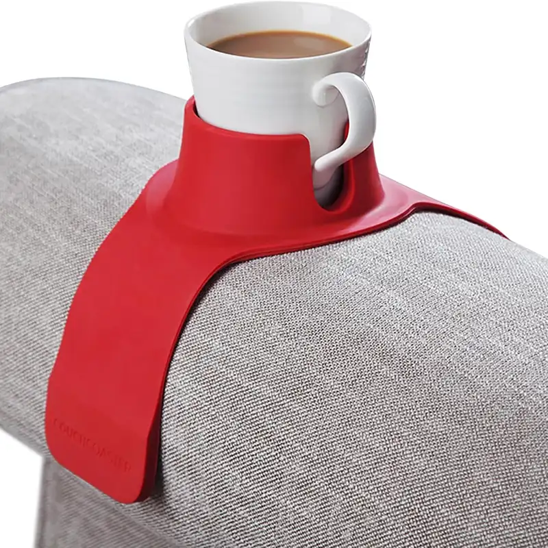 Red CouchCoaster holding a mug of coffee on a grey sofa arm
